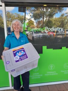 Woman carrying container for Pajama Drive collection